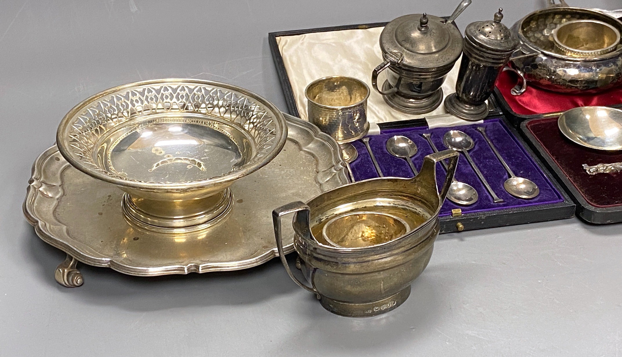 Assorted silverware including an Art Nouveau planished silver tri-handled bowl, Martin, Hall & Co, Birmingham, 1907, 12.5cm, a George V silver salver, a silver 'Guernsey' milk can, a silver sugar bowl, three silver napki